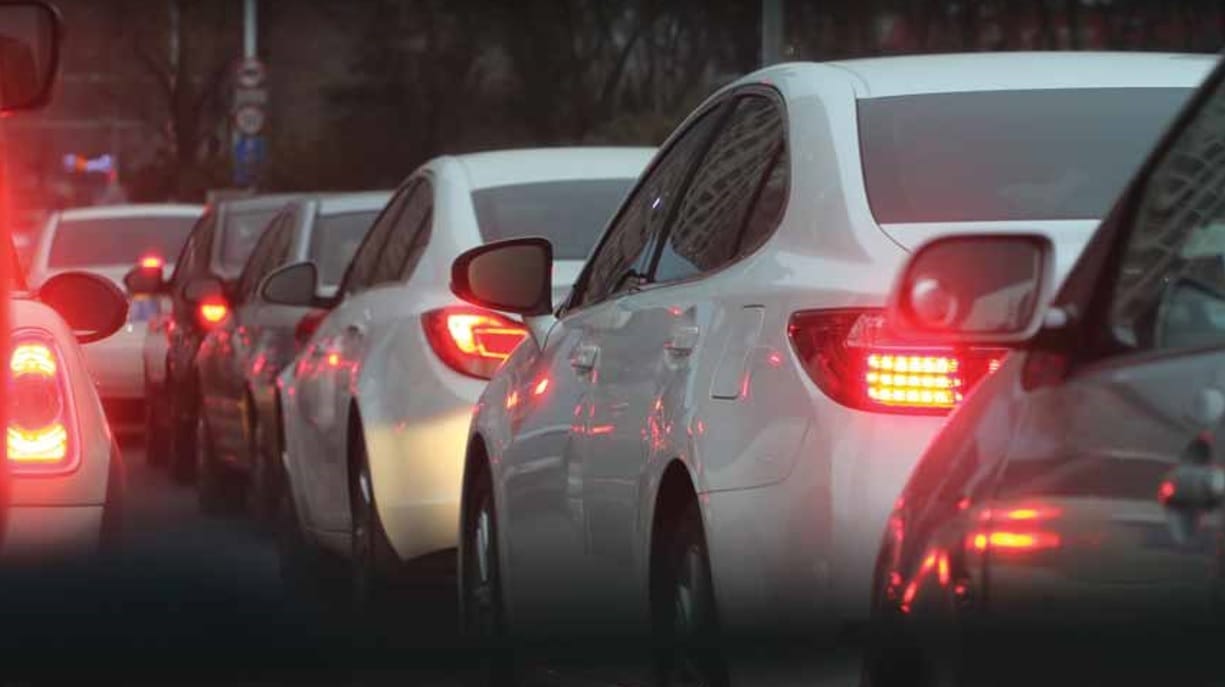 Korek uliczny z samochodami zatrzymanymi na ulicy miasta o zmierzchu.