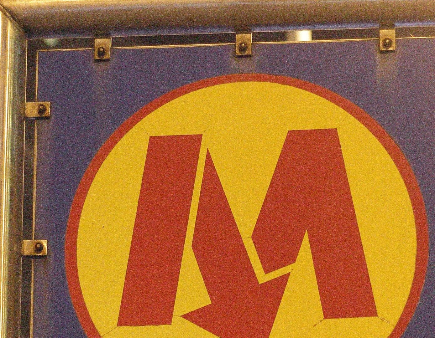 Logo metra moskiewskiego: stylizowane czerwone „M” na żółtym kółku