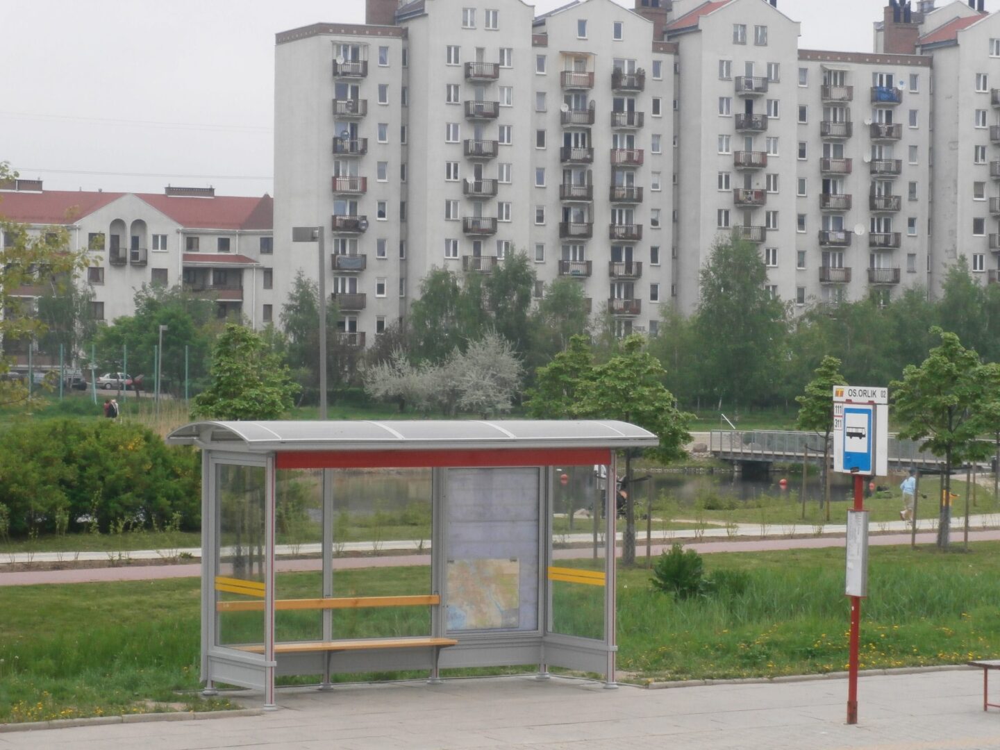 Nowoczesny przystanek autobusowy z ławką, mapą i informacją o trasie (linie 111, 311) na przystanku Orlik.