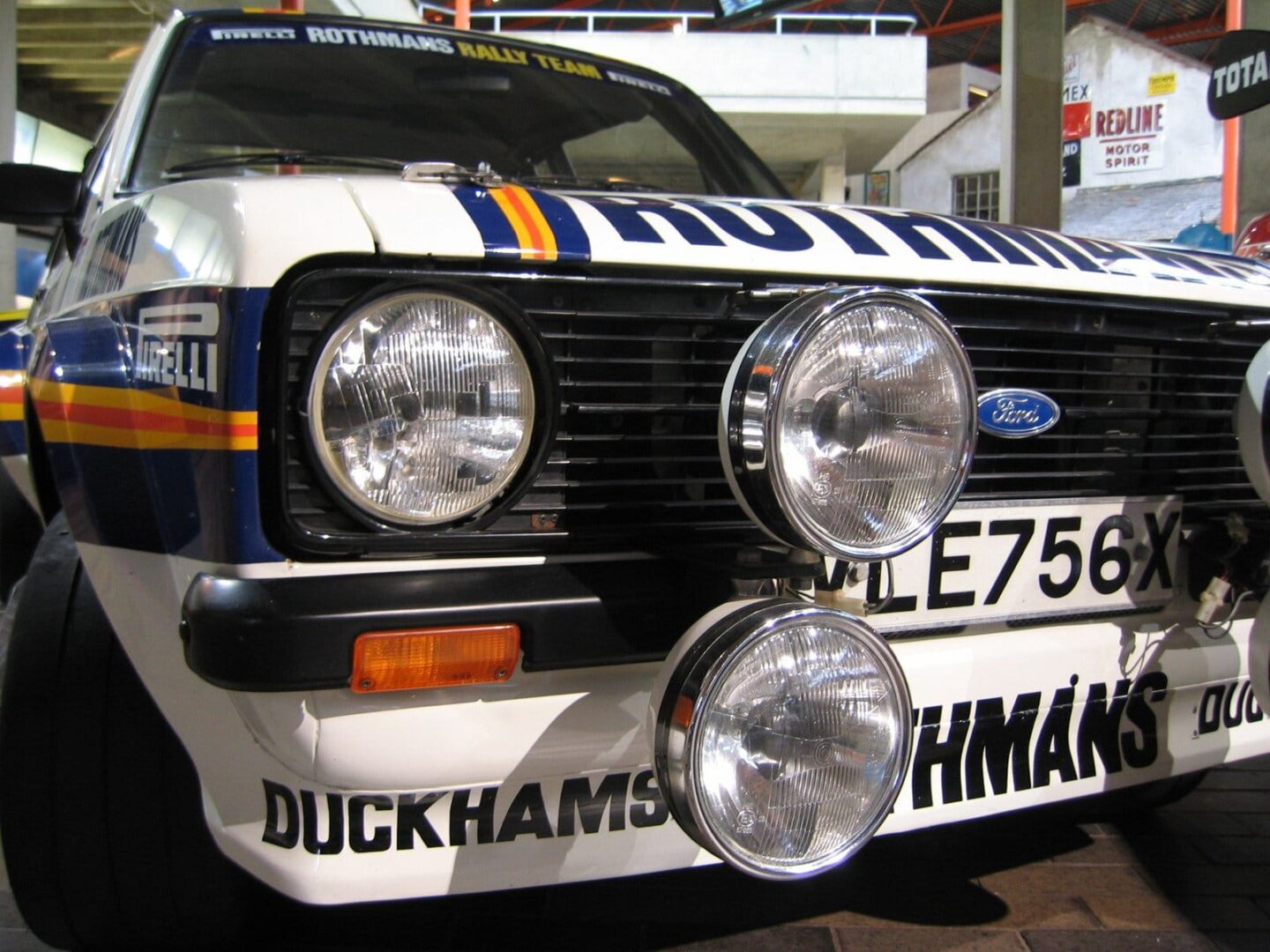Zbliżenie zabytkowego samochodu rajdowego Ford Escort, sponsorowanego przez Duckhams i Rothmans. Tablica rejestracyjna: LE756X.