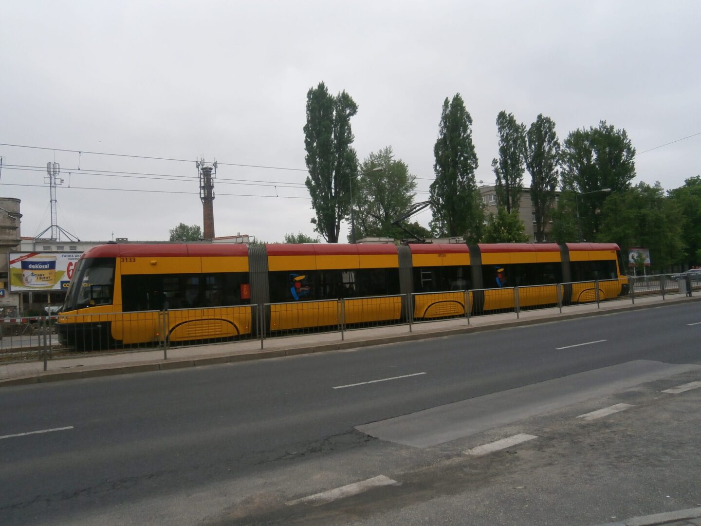 Nowoczesny żółty i czerwony tramwaj numer 3133 na ulicy miejskiej