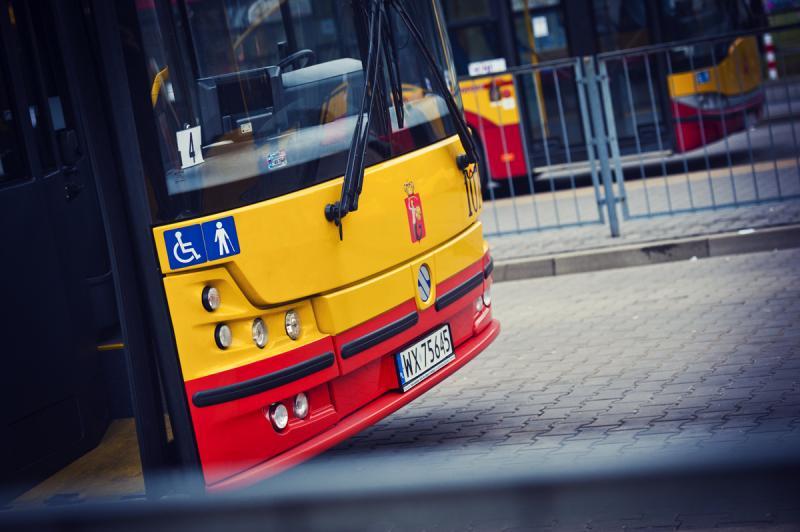 Żółty i czerwony autobus miejski z tablicą rejestracyjną WX 75645, wyświetlany symbol dostępności.