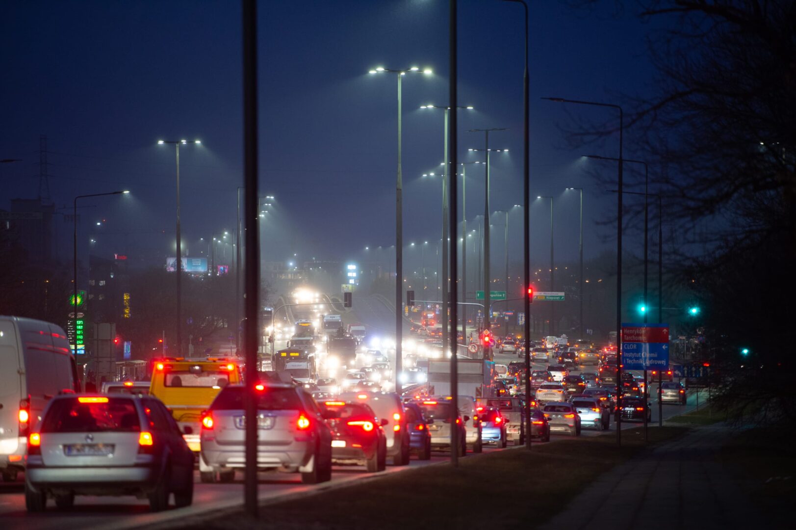 Nocny korek na autostradzie wielopasmowej pod latarniami ulicznymi.