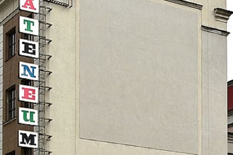 Zewnętrzna część Muzeum Sztuki Ateneum z dużą pustą ścianą i pionowym szyldem.