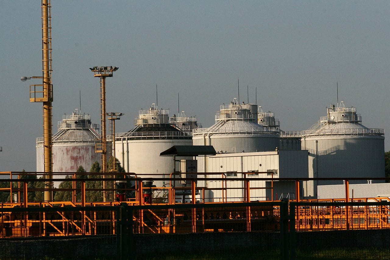 Duże zbiorniki przemysłowe w zakładzie chemicznym lub rafinerii.