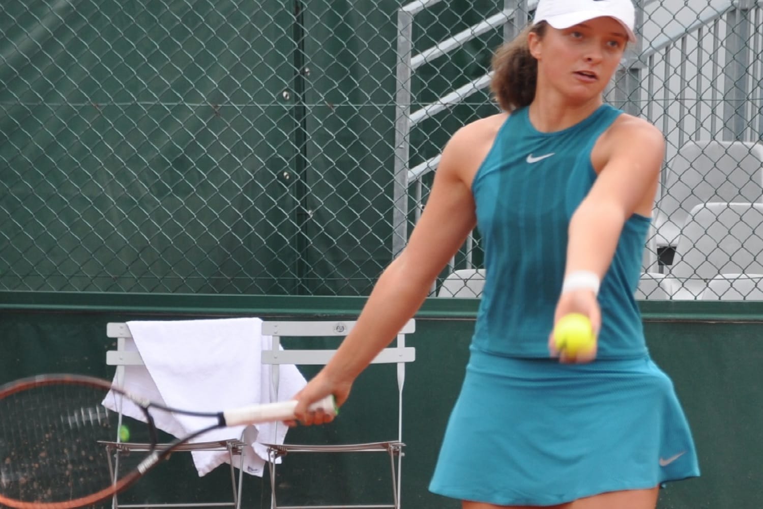 Młody tenisista serwuje piłkę w trakcie meczu.