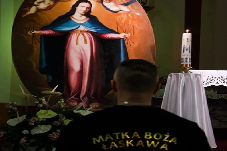 Man prays before painting of Our Lady of Laskava, Matko Boża Łaskawa.