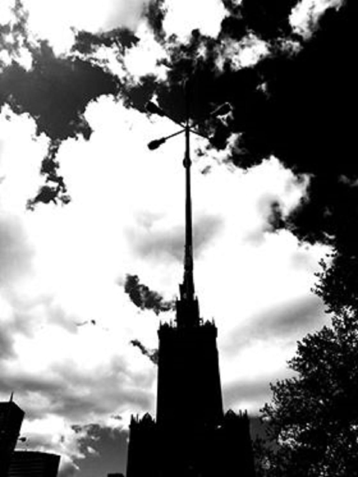 Sylwetka stalinowskiego wieżowca w Moskwie na tle zachmurzonego nieba.