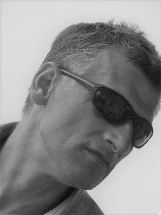 Mężczyzna w okularach przeciwsłonecznych, siwiejące włosy