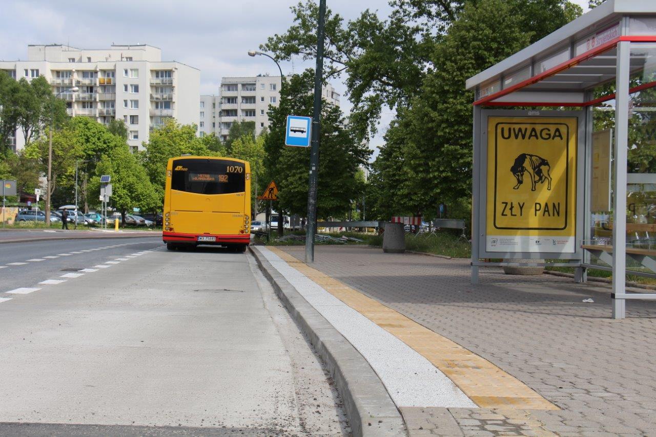 Żółty autobus miejski na przystanku autobusowym z napisem „UWAGA ZŁY PAN”