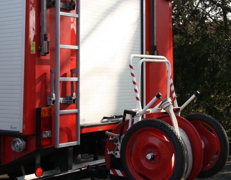 Czerwony wóz strażacki z wężem i drabiną