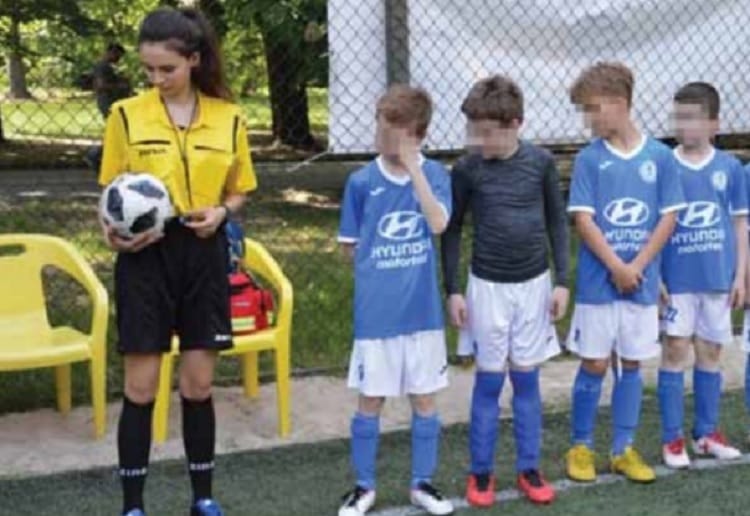 Młoda sędzia z piłkarzami. Mecz piłki nożnej dla młodzieży.