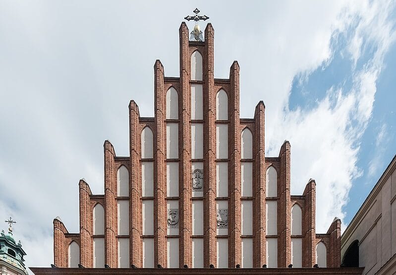 Wieża Kościoła Mariackiego w Gdańsku, prezentująca misterne ceglane zdobienia i gotycką architekturę.