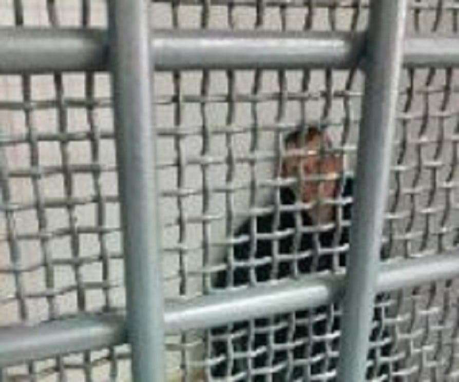 Mężczyzna za kratkami w celi więziennej