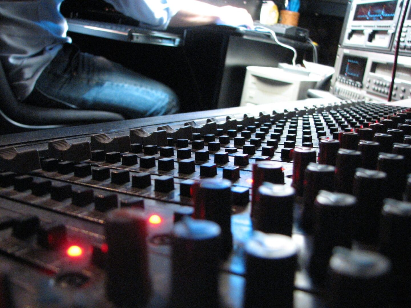 Zbliżenie konsoli miksującej dźwięk z suwakami i pokrętłami; sprzęt do inżynierii dźwięku.