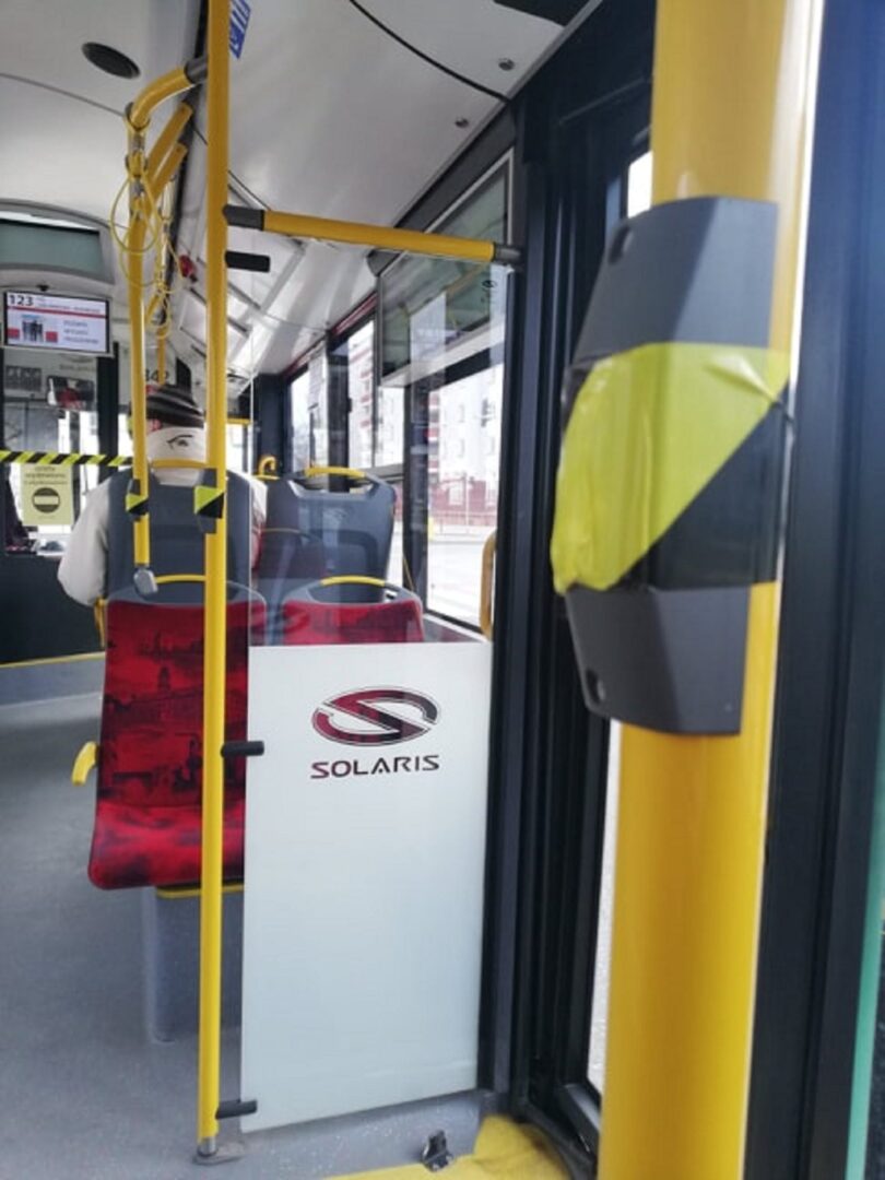 Wnętrze autobusu Solaris, widoczne siedzenia pasażerów i bariera bezpieczeństwa.
