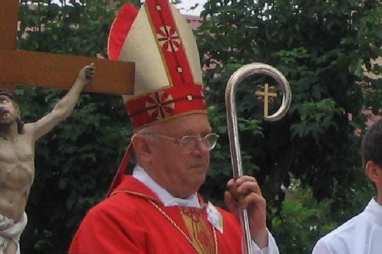 Biskup w czerwonych szatach z pastorałem, odprawiający mszę