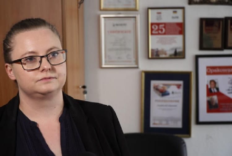 Portret kobiety w okularach w środowisku profesjonalnym.