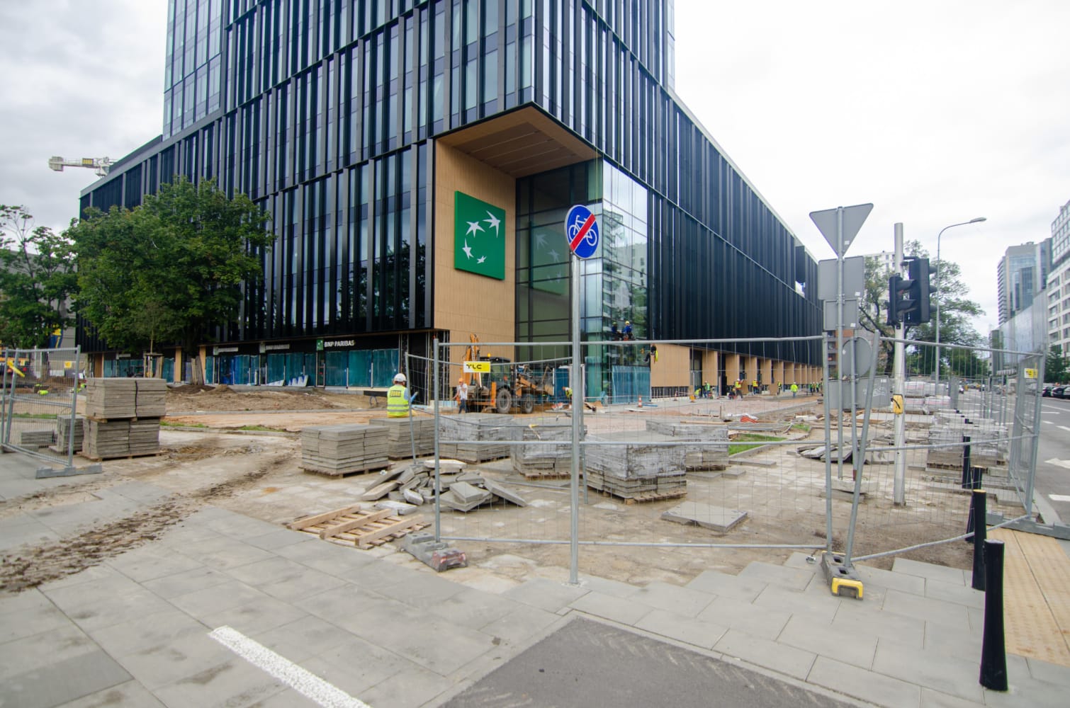 Plac budowy w pobliżu budynku BNP Paribas. Płyty chodnikowe i pracownicy.
