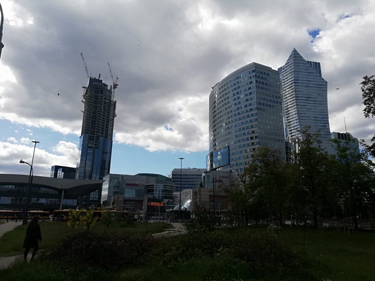 Panorama Warszawy z nowoczesnymi wieżowcami i budynkiem w budowie.