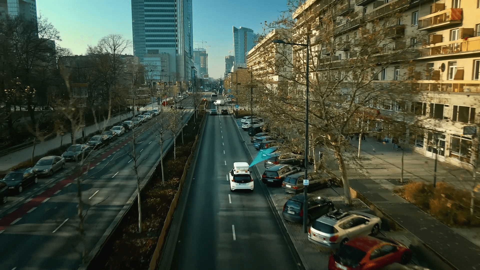 Widok z lotu ptaka na ulicę miejską z samochodami i zaparkowanymi pojazdami. Jazda autonomicznym pojazdem.