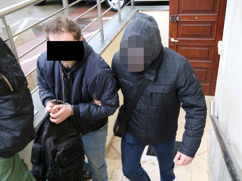 Dwóch aresztowanych mężczyzn, jeden w kajdankach, podejrzanych o kradzież skutera w Warszawie. Francuscy turyści.