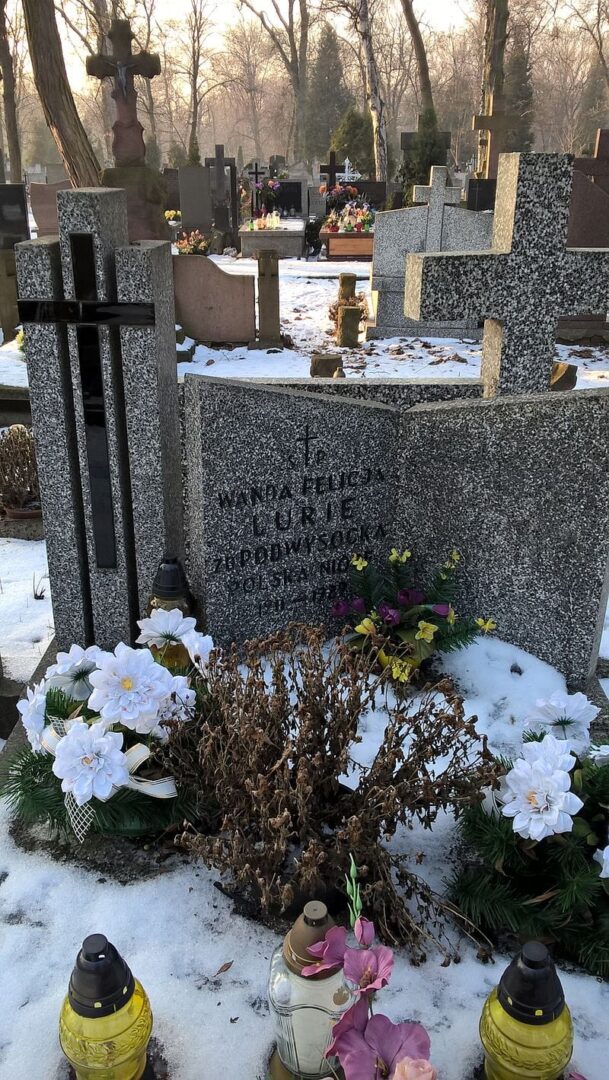 Nagrobek Wandy Felicji Luriski na zaśnieżonym cmentarzu.