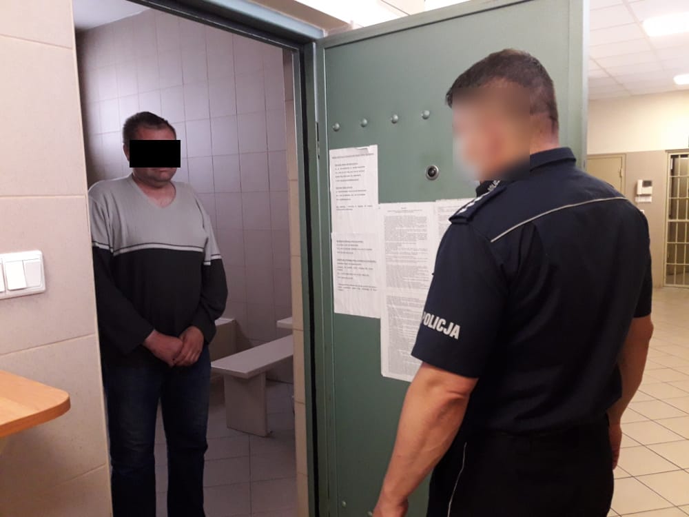 Policjant z aresztowanym mężczyzną w celi więziennej