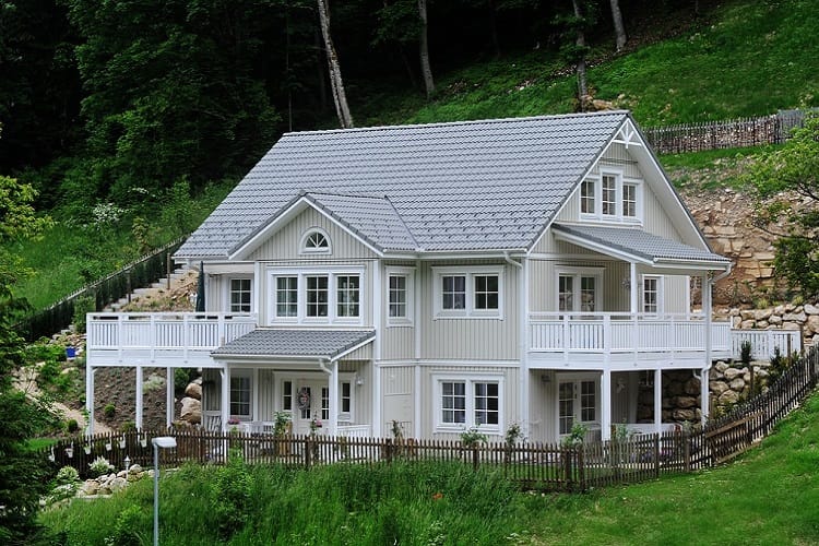 Dwupiętrowy dom w stylu rzemieślniczym z białymi balustradami i szarym dachem