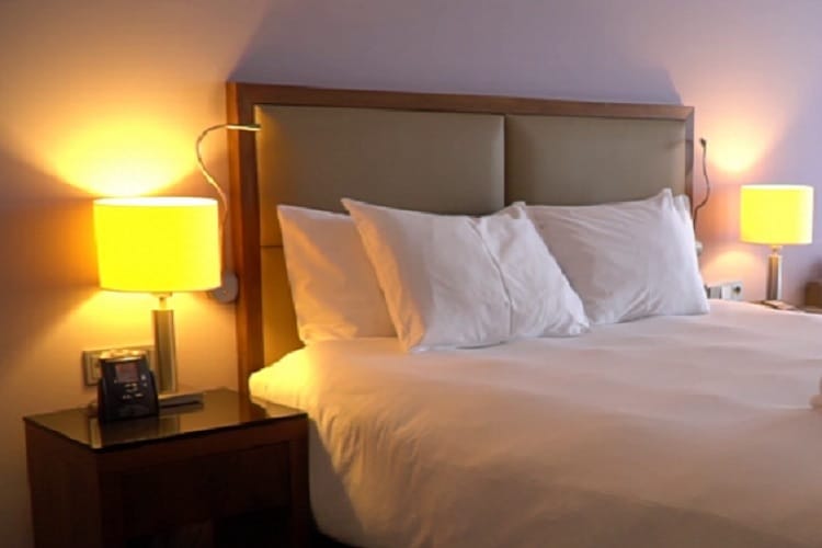 Pokój hotelowy z wygodnym łóżkiem, szafkami nocnymi i lampami.