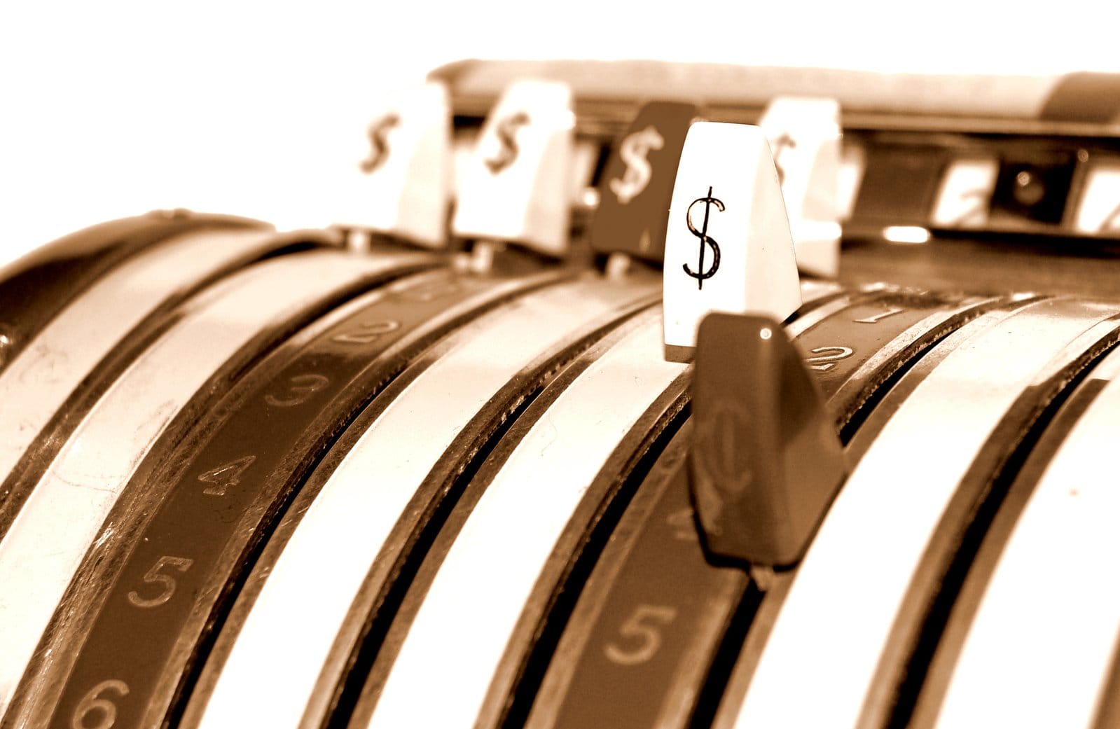 Zbliżenie na klucze do starej kasy fiskalnej ze znakami dolara.