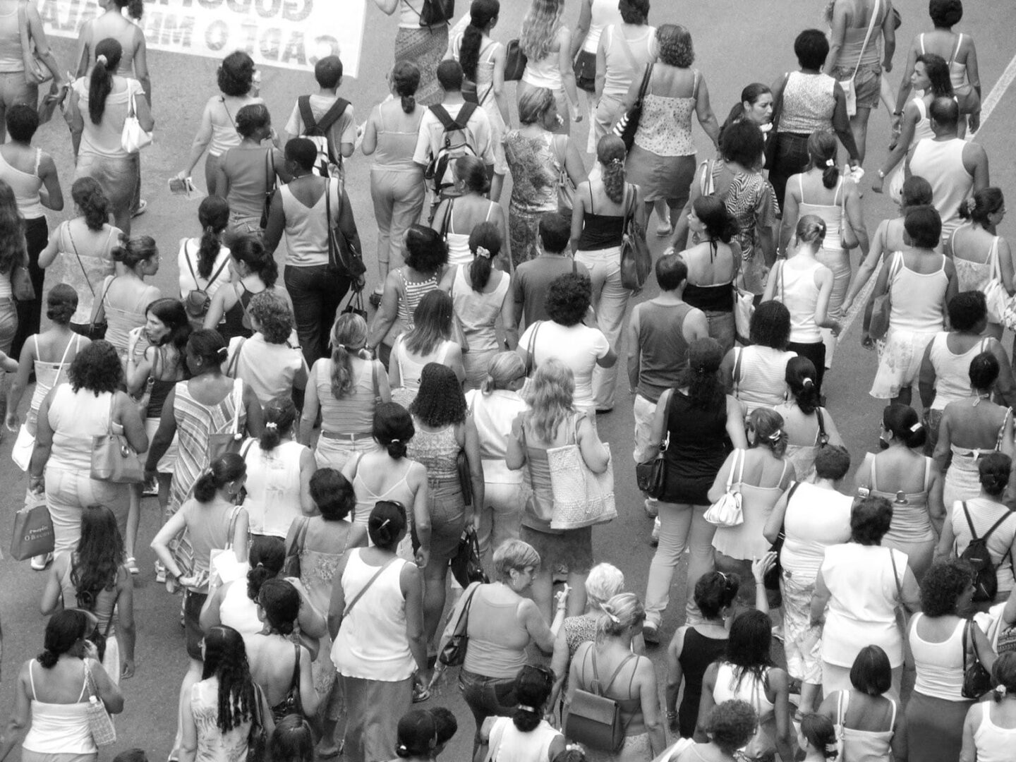 Duży tłum kobiet idących razem, wiele z nich niosących torby.