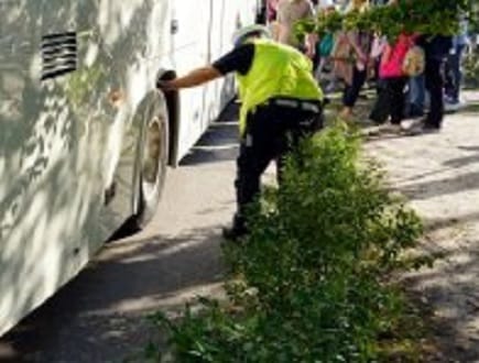Pracownik transportu sprawdzający oponę autobusu