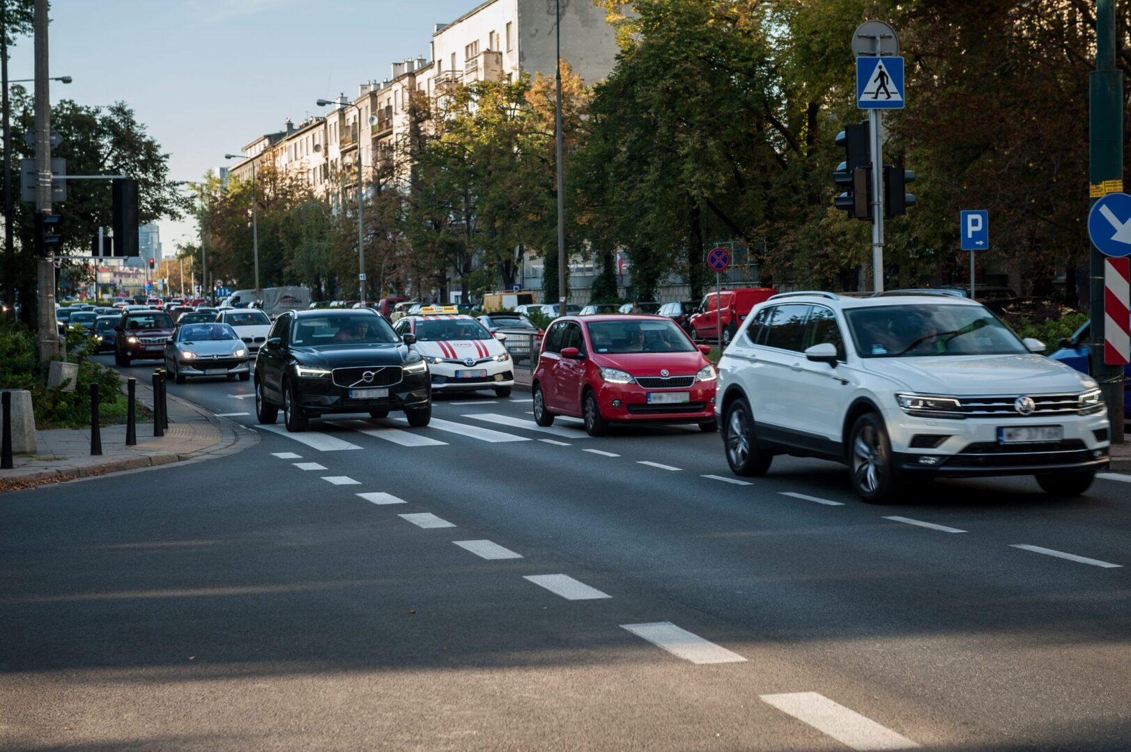 Scena ruchu ulicznego w mieście, z samochodami przejeżdżającymi przez przejście dla pieszych.