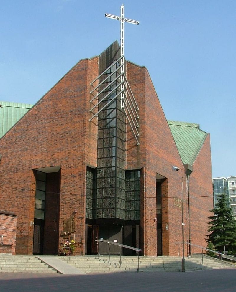 Nowoczesny kościół z cegły z dużym krzyżem i szklanym wejściem