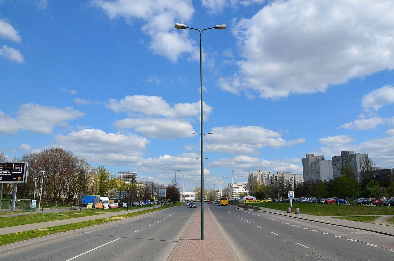 Pusta ulica miejska z wysoką latarnią i budynkami mieszkalnymi w tle