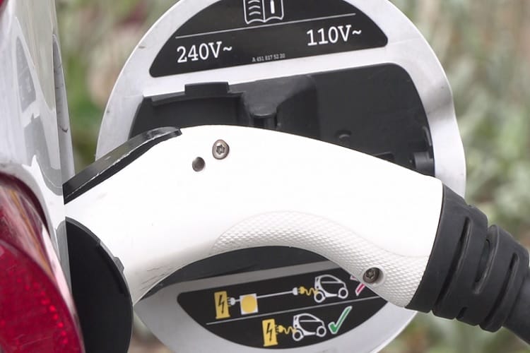 Wtyczka ładowania pojazdu elektrycznego podłączona do stacji ładowania 240 V/110 V.