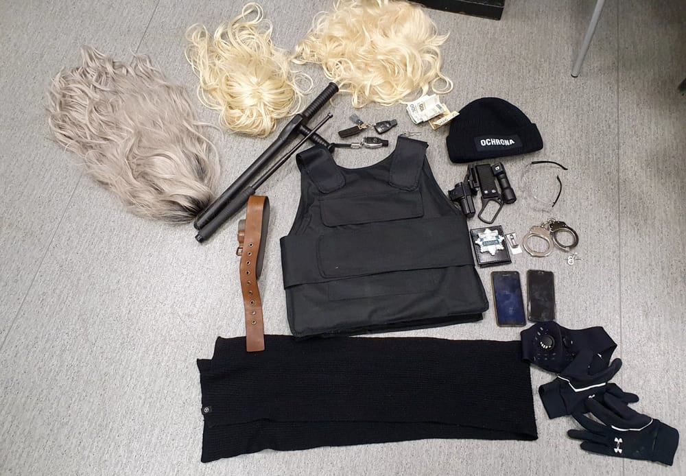 Dowody z policyjnego nalotu: kamizelki kuloodporne, peruki, pałki, kajdanki i inne przedmioty.