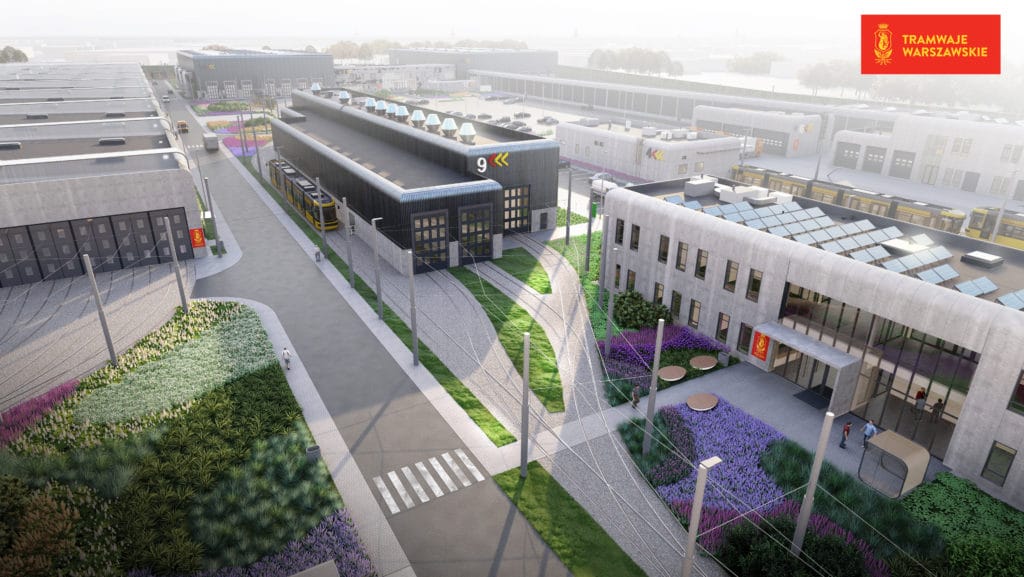 Widok z lotu ptaka na nowoczesną zajezdnię tramwajową z zielenią i torami.