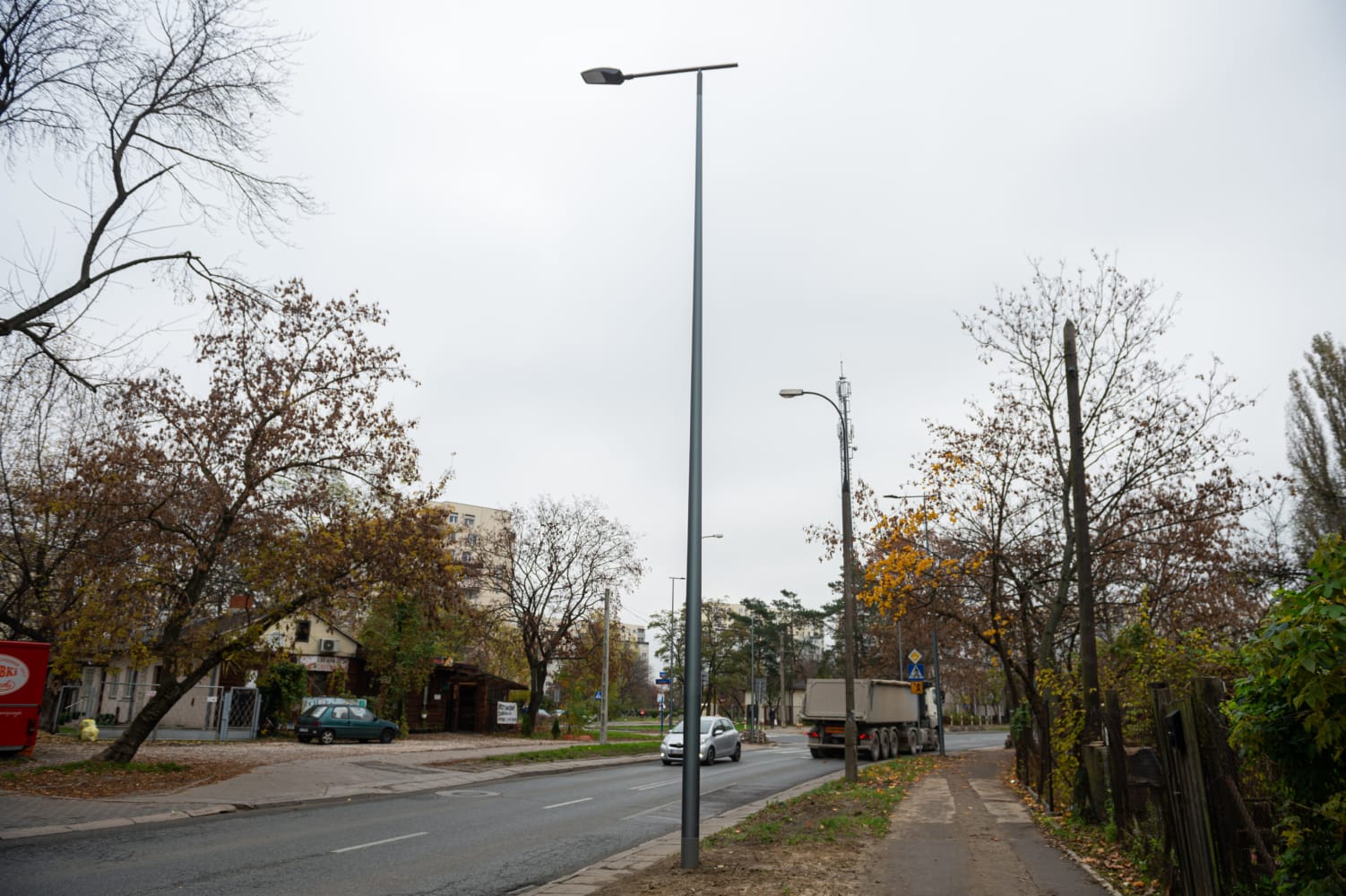 Jesienny widok na ulicę z nowymi latarniami ulicznymi i ciężarówką