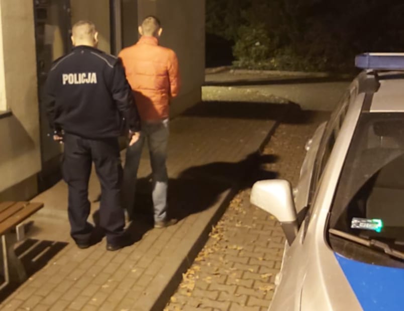 Policjant aresztujący podejrzanego w nocy. POLICJA