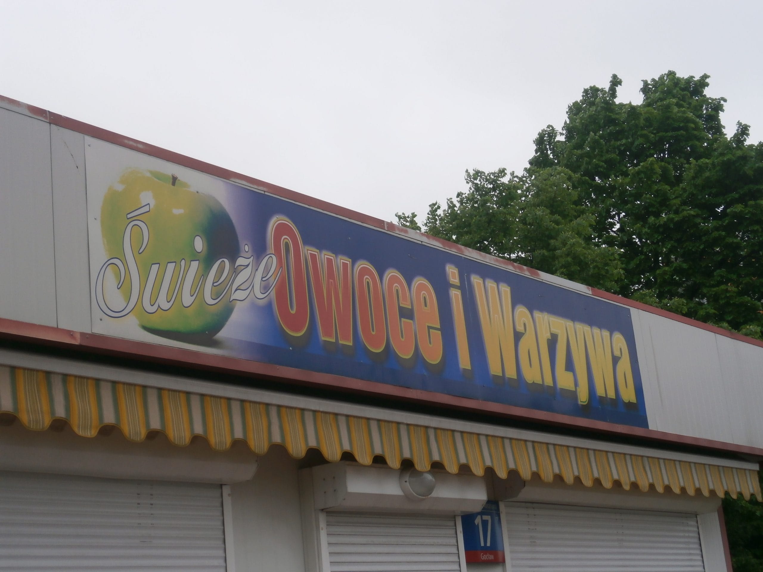 Fresh fruit and vegetable stand with sign reading "Świeże Owoce i Warzywa