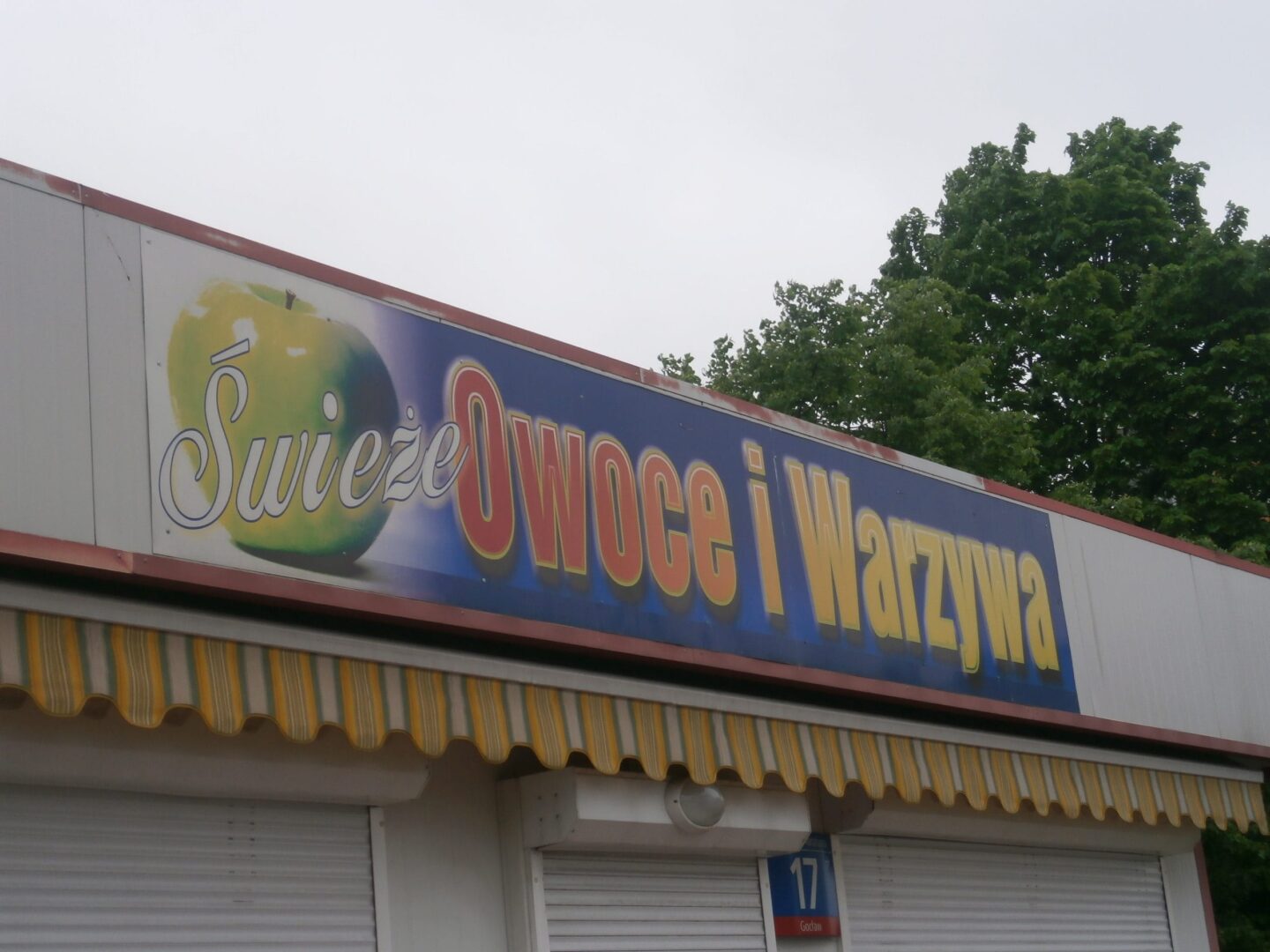 Świeże Owoce i Warzywa stand with striped awning