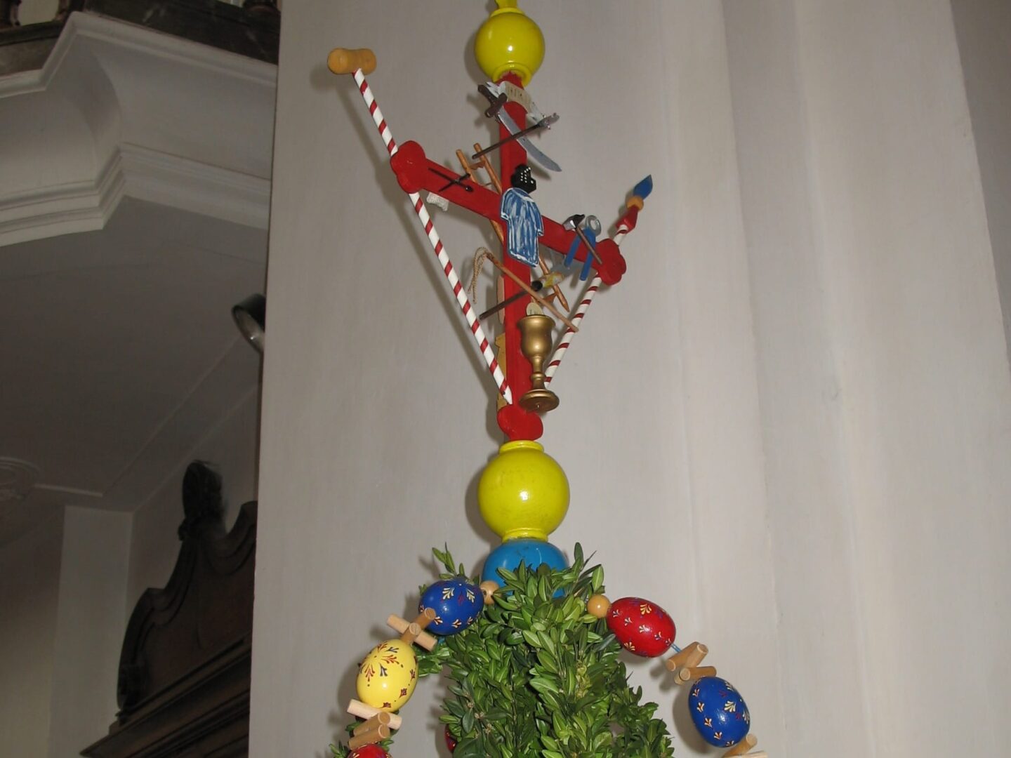 Udekorowana palma wielkanocna z kolorowymi jajkami i krucyfiksem. Zostań w domu i udekoruj swoje okno kwiatami lub palmą.