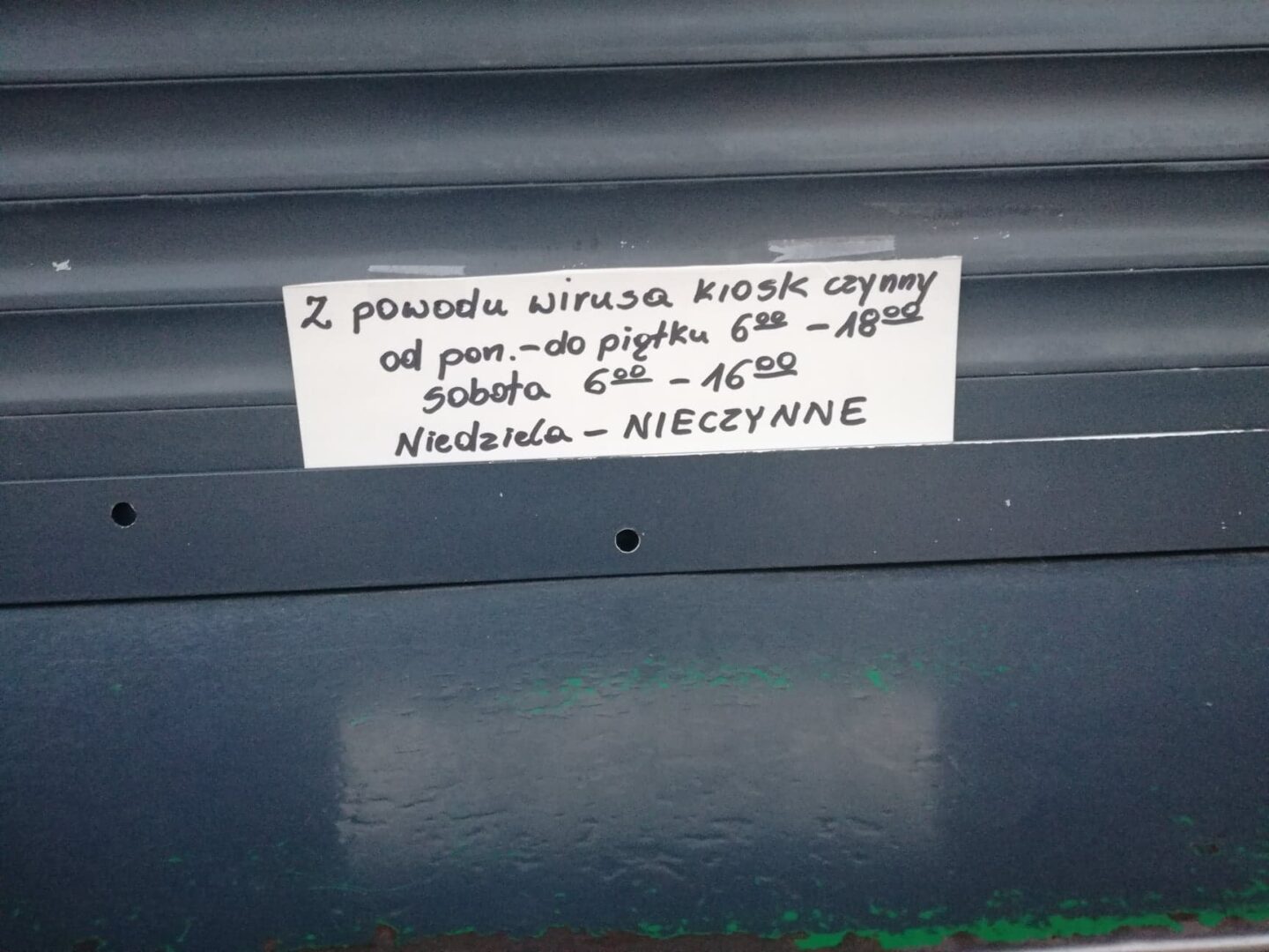 Odręczny znak na kiosku: Ze względu na wirusa, czynne od poniedziałku do piątku w godzinach 18:00-18:00, w soboty w godzinach 18:00-16:00, w niedziele zamknięte.
