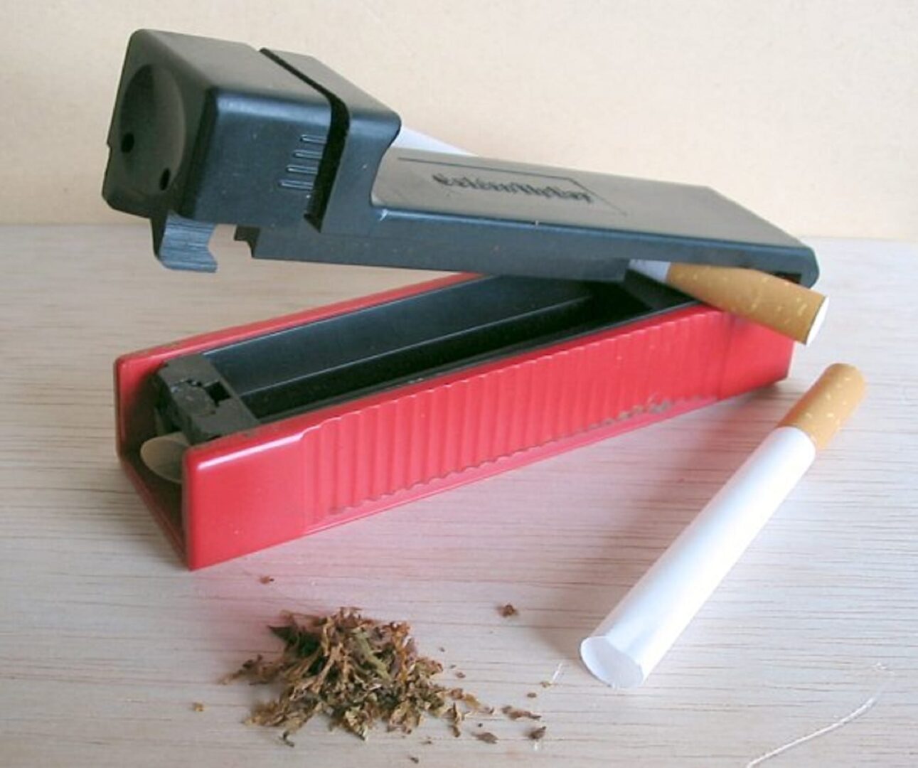 Czerwony wałek do papierosów z tytoniem i papierosami