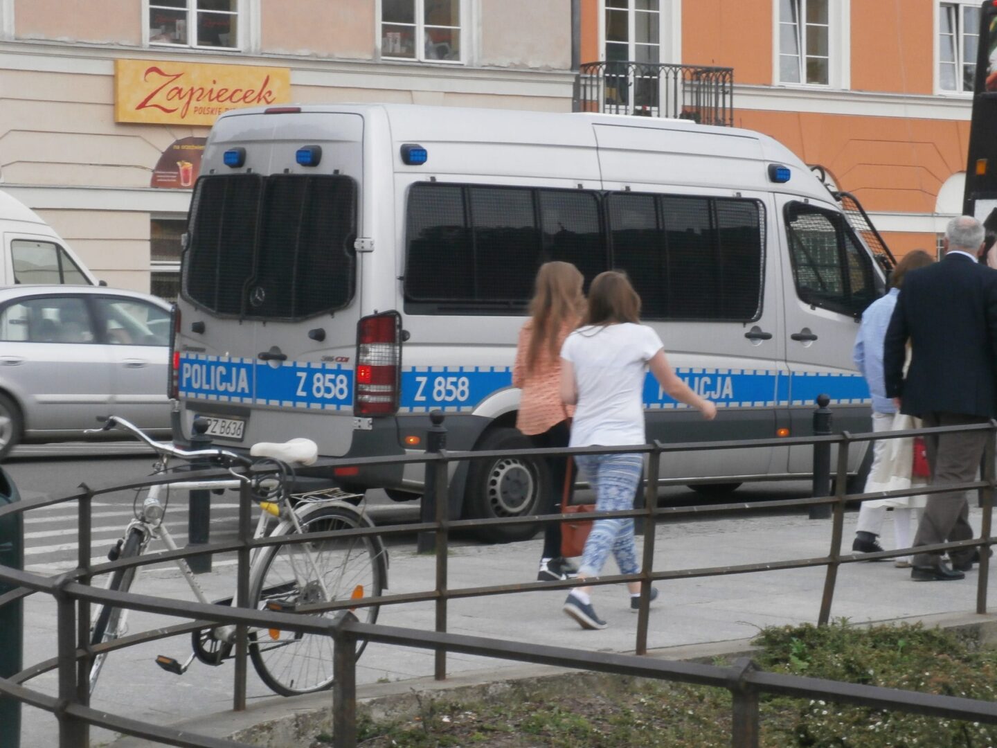 Polski samochód policyjny Z 858 zaparkowany na ulicy miejskiej w pobliżu pieszych