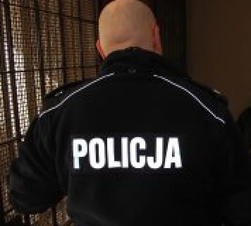 Plecy polskiego policjanta, na mundurze wyraźnie widoczny napis „POLICJA”.