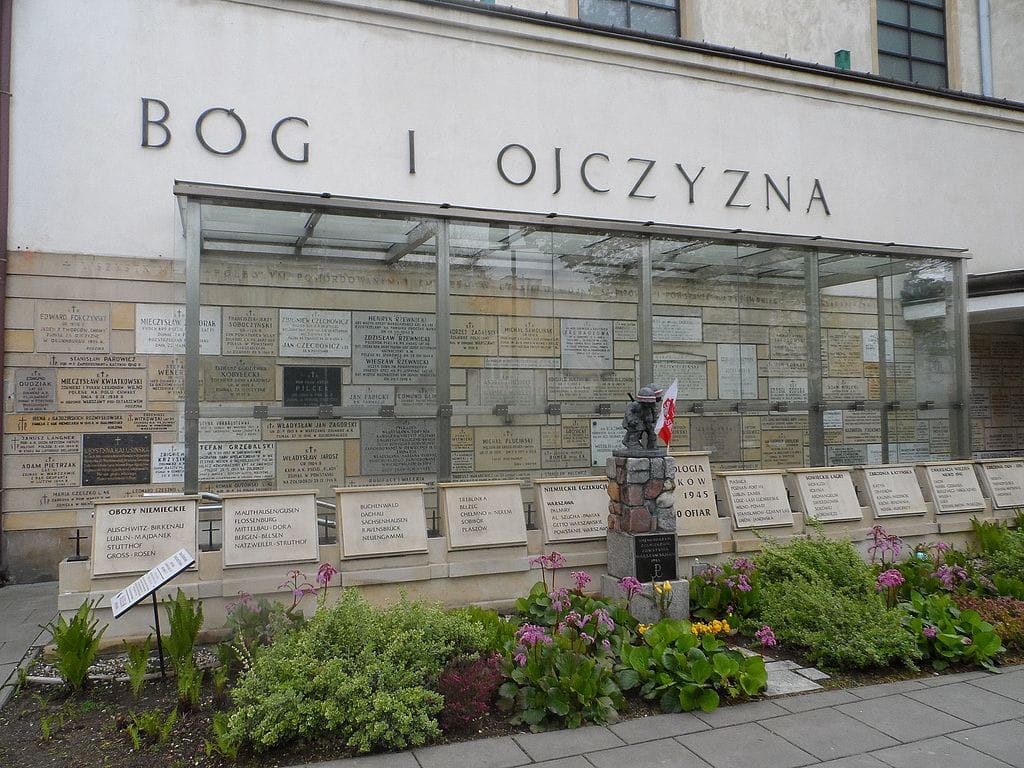 Ściana pamięci z tablicami upamiętniającymi ofiary II wojny światowej, na których znajduje się napis „Bóg i Ojczyzna”.