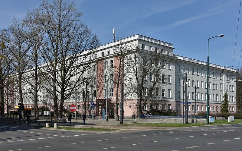 Duży budynek szkoły na rogu ulicy miejskiej